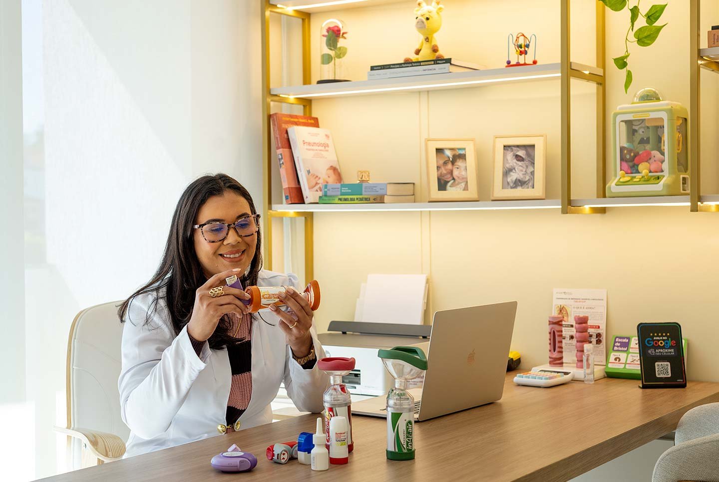 Dra. Layla Matos no consultório, explicando o uso do espaçador e dos dispositivos inalatórios